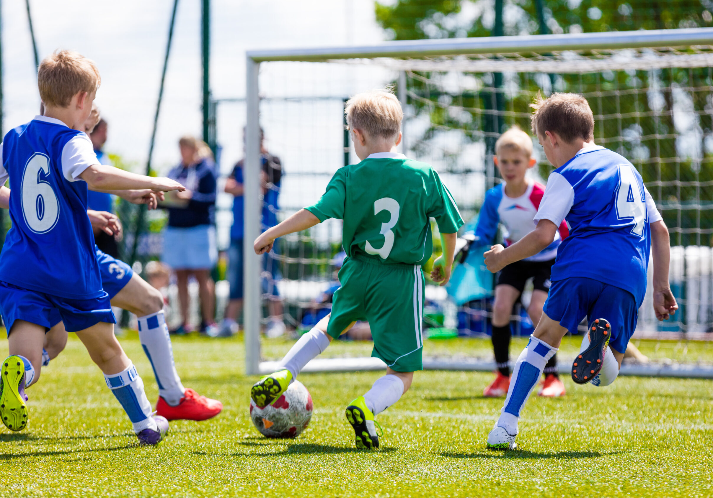 Football soccer match for children. Boys playing football game on a school tournament. Dynamic, action picture of kids competition during playing football. Sport background image.